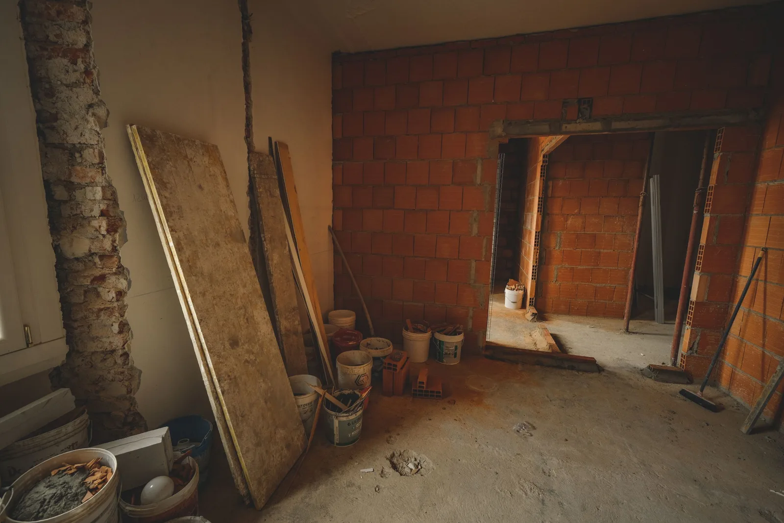 Mur de refends en pierre dans une maison ancienne, vu depuis une pièce en travaux